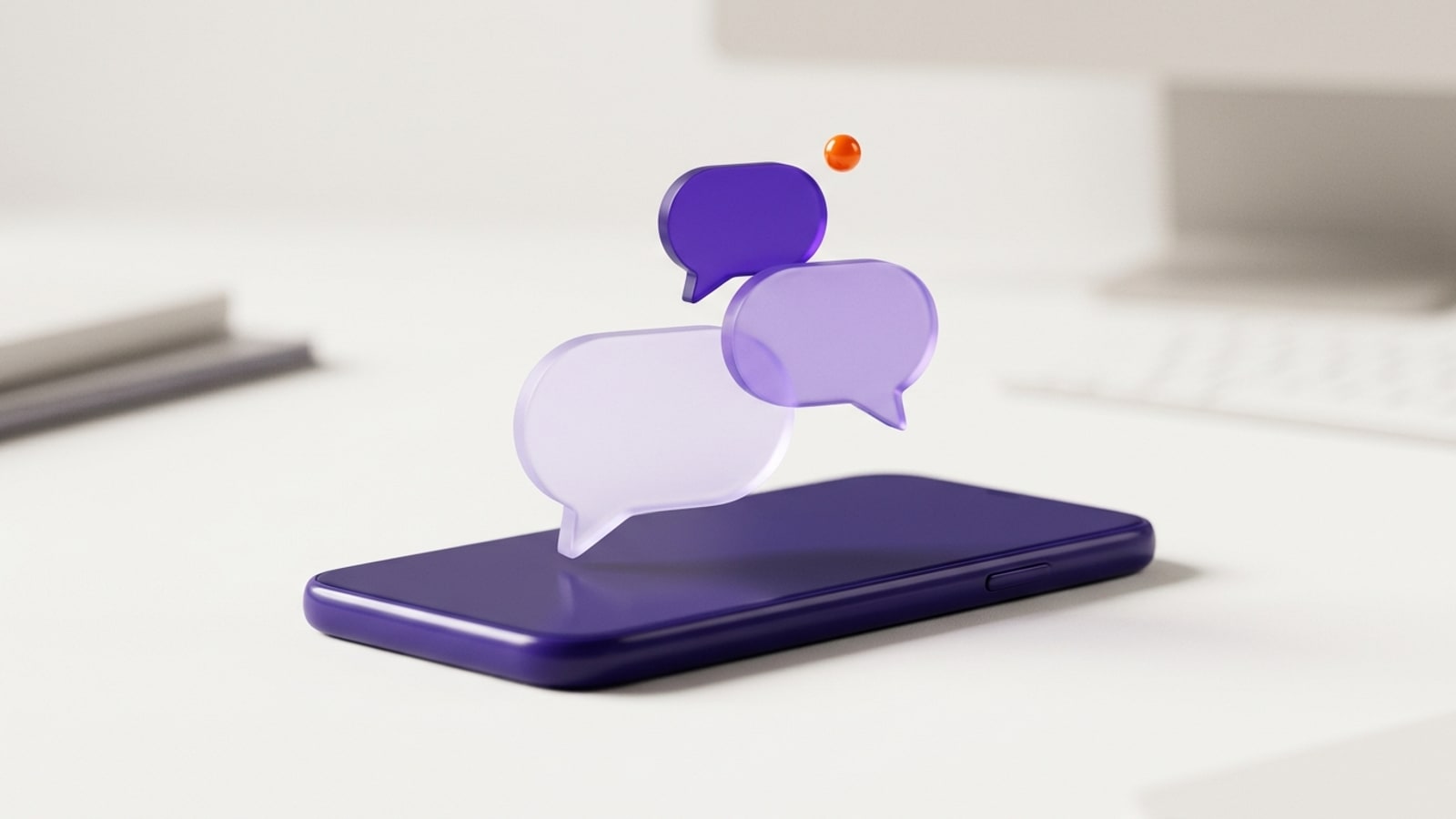 Render 3D minimalista sobre uma mesa clara: um celular violeta-escuro deitado, de tela apagada, e acima dele três balões de conversa flutuando — dois de vidro lilás fosco, um maior e outro menor sobrepostos, e um violeta sólido no alto. Ao lado do balão violeta paira uma pequena esfera laranja, como um aviso de mensagem nova. Ao fundo, um teclado e livros desfocados.